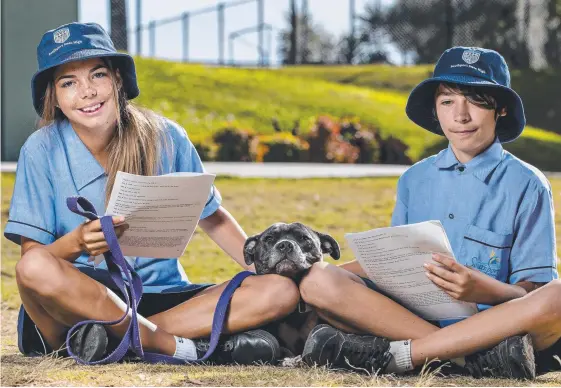  ?? Picture: JERAD WILLIAMS ?? Southport State High School students Zakeira Chatfielz and Zane Giles, both 13, read to English staffy Arlo. The community raised money last year so the dog could walk again after she was diagnosed with neosporosi­s at 12 weeks of age (inset).