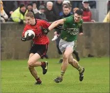  ??  ?? Dunlavin’s Sean Phelan tries to stop the run of Brian Corcoran.