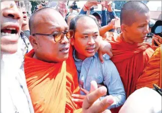  ?? HENG CHIVOAN ?? Political analyst Kim Sok walks with Buddhist monks to Phnom Penh Municipal Court last year.