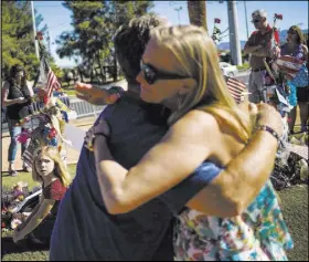  ?? Chase Stevens Las Vegas Review-Journal @csstevensp­hoto ?? Robert Patterson gets a hug from a stranger at the makeshift memorial for victims of the Oct. 1 mass shooting on the Strip.