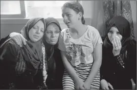  ?? AP/KHALIL HAMRA ?? Relatives of 15-year-old Ameer al-Nimra, who was killed along with another teenager on Saturday in an Israeli airstrike on Gaza, mourn during his funeral in the family home Sunday in Gaza City.