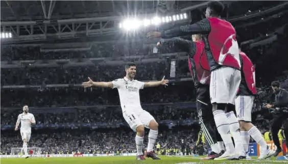  ?? EFE / JUANJO MARTÍN ?? Marco Asensio celebra el 2-0 del Real Madrid con sus compañeros en la banda.