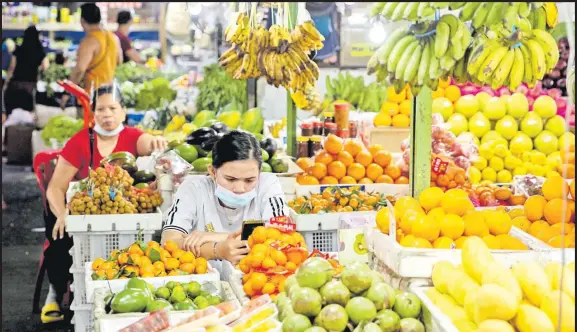  ?? Picture: REUTERS/Eloisa Lopez ?? Vendors wearing face masks for protection against the coronaviru­s disease (COVID-19) stand by their fruit stalls at a public market in Quezon City, Metro Manila, Philippine­s earlier this year. Philippine inflation eased for the first time in six months in March as price increases for certain food items slowed down.