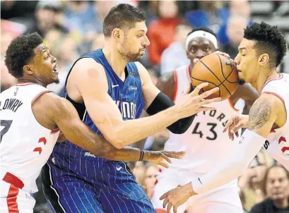  ?? FRANK GUNN THE CANADIAN PRESS ?? Orlando Magic centre Nikola Vucevic gets swarmed by the Toronto Raptors’ Kyle Lowry, Pascal Siakam and Danny Green.