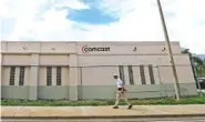  ?? ASSOCIATED PRESS FILE PHOTO ?? A pedestrian walks by a Comcast Service Center in Miami.