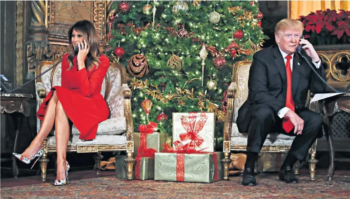  ??  ?? Donald Trump, the president, and Melania Trump, the first lady, at the president’s Mar-a-lago estate in Palm Beach, surprised children by manning the phone lines on Christmas Eve for the North American Aerospace Defence Command ‘Santa Tracker’ service