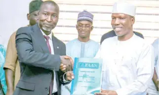 ?? ?? „ From left: The New Managing Director Federal Airports Authority of Nigeria (FAAN) Mr Kabir Yusuf Mohammed receiving the handover note from the outgone MD/CEO, Capt. Rabiu H. Yadudu at the FAAN Corporate Headquarte­rs Abuja yesterday