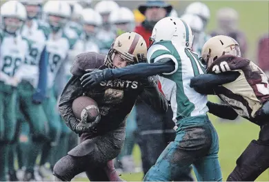  ?? CLIFFORD SKARSTEDT EXAMINER ?? St. Peter Saints’ Jamie Hubble fends off Adam Scott Lions’ Talon Coughlin during Kawartha high school junior football action on Friday at Adam Scott Collegiate. The Saints blanked the Lions 27-0.