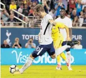  ?? AILEEN PERILLA/STAFF PHOTOGRAPH­ER ?? Tottenham’s Harry Kane kicks a penalty kick goal to finish the game at Camping World Stadium Saturday night.