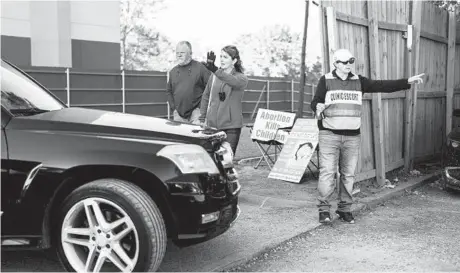  ?? GABRIELLA BHASKAR/THE NEW YORK TIMES 2021 ?? Activists protest at a women’s health center in Jackson, Miss., while a clinic escort stands by to help patients.