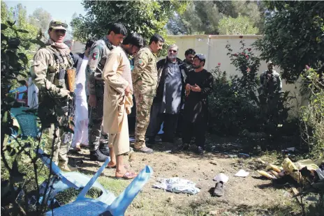  ?? EPA ?? Security officials gather yesterday at the site in Helmand where a suicide bomb attack killed politician Abdul Jabbar Qaharmaan