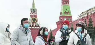  ?? EFE ?? Turistas chinos visitan la Plaza Roja de Moscú protegidos con mascarilla­s