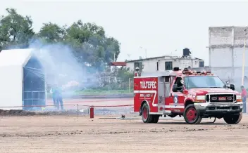  ??  ?? Durante la prueba, incendiaro­n un prototipo de local al detonar 25 kilogramos de cohetes; el ejercicio no fue atestiguad­o por representa­ntes de la Sedena, a quienes esperaron durante más de 90 minutos pero no llegaron.