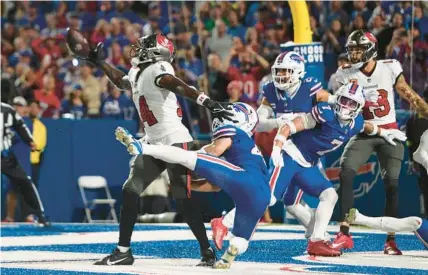  ?? ADRIAN KRAUS/AP ?? Bucs receiver Chris Godwin, left, reaches for but can’t catch a Hail Mary pass in front of Bills linebacker Terrel Bernard, center, safety Micah Hyde, rear center, and cornerback Taron Johnson at the end of Thursday night’s game.