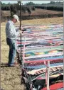  ??  ?? Profession­al land surveyor Kevin Melhuish records the length of the 29.18km scarf created by 67 Blankets for Nelson Mandela Day KnitWits.