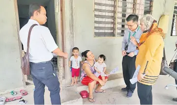  ??  ?? Health team members are seen interviewi­ng residents of Kampung Paon Sungai Rimu.