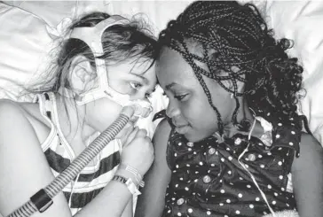  ?? MURNAGHAN FAMILY VIA AP ?? Sarah Murnaghan, left, lies in a hospital bed next to her adopted sister, Ella, during her stay in Children’s Hospital of Philadelph­ia in May. Murnaghan received a controvers­ial lung transplant last week.