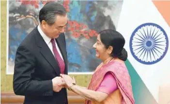  ?? — AFP ?? External Affairs Minister Sushma Swaraj with China’s Foreign Minister Wang Yi as a press conference begins at the Diaoyutai State Guest House in Beijing on Sunday.