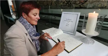  ??  ?? Patricia Howe, from Bray, Co Wicklow, signing the Book of Condolence at the Town Hall in Dun Laoghaire. Photo: Steve Humphreys