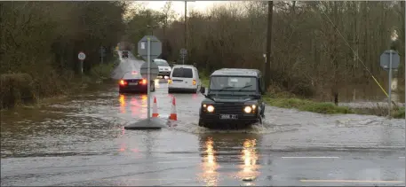  ??  ?? Traffic negotiate flood waters at the Ballymaqui­rke junction on the approach road to Kanturk. Picture John Tarrant