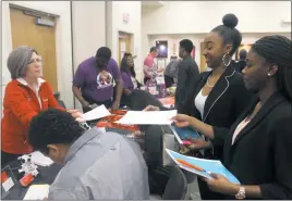  ??  ?? Waldorf residents Johnelle Wallace, 16, and Aniya Sorrell, 16, hand their already filled out job applicatio­ns to Kathy Levanduski, human resources director at Chick-fil-A in Waldorf, during the Young Adult Job Fair on March 22.