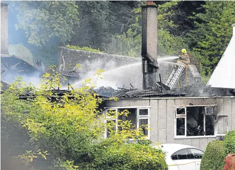 ?? Photograph by Sandy McCook ?? BLAZE: Firefighte­rs deal with the overnight fire in a house at Island Bank Road, Inverness.