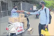  ??  ?? Mahesh Bankar (left) hands over a water bottle to a passerby, in Kalyan (W).