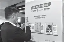  ?? HU PING / FOR CHINA DAILY ?? A passenger scans a QR code for listening to audio content through an “audio library” app at the Changzhou North subway station in Changzhou, Jiangsu province, on April 21.