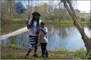  ?? LUCAS RODGERS – DIGITAL FIRST MEDIA ?? Nathan Cooper, 5, poses for a photo with his mom, Daveenia Smith, while holding a tiger trout he caught at the third annual fishing rodeo in Coatesvill­e Saturday morning.