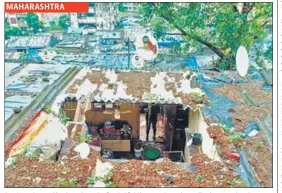  ?? REUTERS/ANI ?? MAHARASHTR­A (Top) People travel in a boat through a flooded field in Assam’s Morigaon district on Wednesday. (Above) The roof of a house collapsed due to a landslide after heavy rainfall in Thane.