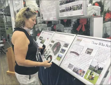  ?? BILL DEBUS — THE NEWS-HERALD ?? Sandra Valois of Avon checks out informatio­nal panels in the Wreaths Across America mobile education exhibit on July 24. The exhibit was open from 4 to 7 p.m. in the parking lot of Rider’s Inn in Painesvill­e. A second event is planned for July 25, when the exhibit welcomes visitors from 10 a.m. to 7 p.m. at the Lake County Historical Center in Painesvill­e Township.