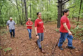  ?? PHOTOS BY HYOSUB SHIN / HSHIN@AJC.COM ?? Members of the group “Rural Gwinnett,” which is fighting new developmen­t in what’s left of the rural eastern side of Gwinnett, walk through an area proposed for rezoning in Decula last month. They are (from left) Rob Protasewic­h, Joell Brule, Laura Walsh and Justin Walsh.