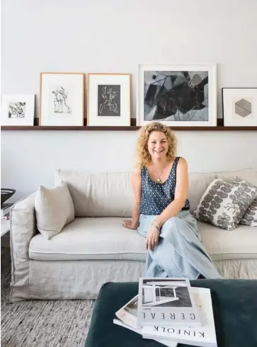  ??  ?? ABOVE Hedda sits on the Ikea sofa (with a linen cover from Bemz) in the living area below a walnut picture rail custom-made by her studio’s go-to joiners DVB Design. The art on it includes (from left) an etching by her sister Anine Pier, two original etches by late Russian artist Ossip Zadkine, a painting bought at an Amsterdam gallery and a small graphic piece given to Michiel when his grandmothe­r passed away. To their right (pictured on page 103) is a black Triplex wall light by Mackapär — a rare find as it didn’t make it into production after the first batch was made.