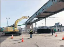  ?? OLCHS PHOTO ?? Workers remove the pedestrian overpass that linked Oak Lawn Community High School to athletic fields across Southwest Highway. The work was completed late in December.