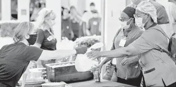  ?? CALVARY CHAPEL ?? Volunteers from Calvary Chapel in Fort Lauderdale hand out food to employees at Holy Cross Hospital as part of the church’s pandemic response.