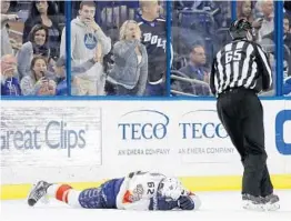  ?? CHRIS O'MEARA/AP ?? Panthers center Denis Malgin (62) covers up on the ice after getting checked by Tampa Bay Lightning defenseman Anton Stralman during the second period. Malgin suffered a concussion on the play.