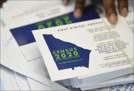  ?? JOHN AMIS—ASSOCIATED PRESS ?? In this Aug. 13, 2019, file photo a worker gets ready to pass out instructio­ns in how fill out the 2020census during a town hall meeting in Lithonia, Ga. The U.S. Census Bureau says a test for the 2020census shows having a question about citizenshi­p didn’t have much of an impact on response rates for the general population, though responses by Hispanics were down slightly.