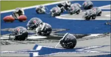  ?? TONY GUTIERREZ — THE ASSOCIATED PRESS ?? Several Houston Texans helmets sit over the Dallas Cowboys logo in the end zone as the Texans prepared for practice at the Cowboys training facility Monday in Frisco, Texas.
