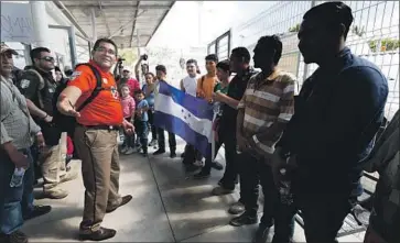  ?? Marco Ugarte Associated Press ?? A MEXICAN immigratio­n official welcomes new arrivals who entered from Guatemala. About 2,000 travelers are expected to apply for temporary immigratio­n status in Mexico. Many hope to reach the United States.