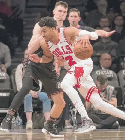  ?? AP ?? Otto Porter, driving against Nets forward Rodions Kurucs, started at small forward in his Bulls debut and scored 18 points.