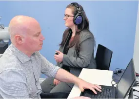  ??  ?? How it’s done Craig Gallagher and Stephanie Gilligan demonstrat­e a hearing test