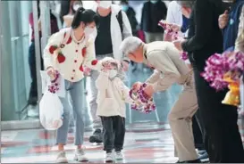  ?? SAKCHAI LALIT / AP ?? Thai Minister of Tourism and Sports Phiphat Ratchakitp­rakarn presents a garland to a Chinese girl after she lands in Thailand on Jan 9.