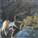  ??  ?? Parker Vivier and Marsden Olsen, both of Richmond, tie their tree to their car.