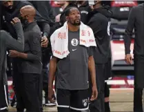  ?? KATHY WILLENS - THE ASSOCIATED PRESS ?? Brooklyn Nets forward Kevin Durant, center, looks at a video replay on the scoreboard above the court during a timeout in the second quarter of a preseason NBA basketball game against the Washington­wizards, Sunday, Dec. 13, 2020, in Newyork.