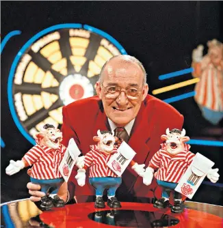  ??  ?? Humble origins: Jim Bowen on the set of Bullseye, and, right, with a speedboat – often one of the show’s star prizes