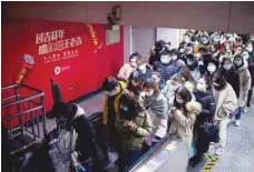  ?? — Reuters ?? People wearing face masks are seen at a subway station following COVID-19 outbreak, in Shanghai, on Monday.