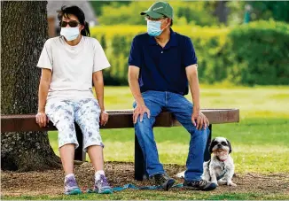  ?? DALLAS MORNING NEWS / AP ?? Raynette and Jeff Ho wear face masks July 2 in Richardson, Texas, after a government order. Arkansas now has such a mandate, but some law enforcemen­t refuses to enforce it.