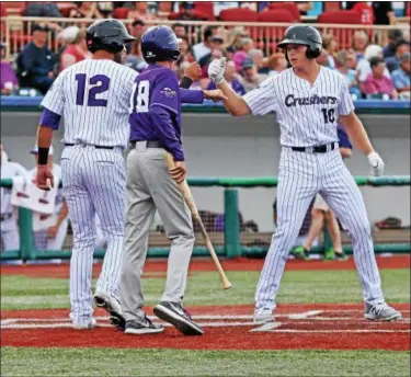  ?? RANDY MEYERS — THE MORNING JOURNAL ?? Austin O’Brien of the Crushers is congratula­ted at home plate after belting a two-run homer during the first inning.