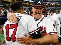  ?? CURTIS COMPTON / CCOMPTON@AJC.COM ?? Braves manager Brian Snitker celebrates with Johan Camargo after Camargo hit a walk-off home run to beat the Mets on May 29.