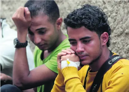  ?? Photos Anees Mahyoub / Reuters ?? Colleagues grieve at the funeral of journalist­s Anwar Al Absi, Taqi Al Hothaifi and Sa’ad Al Nidhari in Taez yesterday.